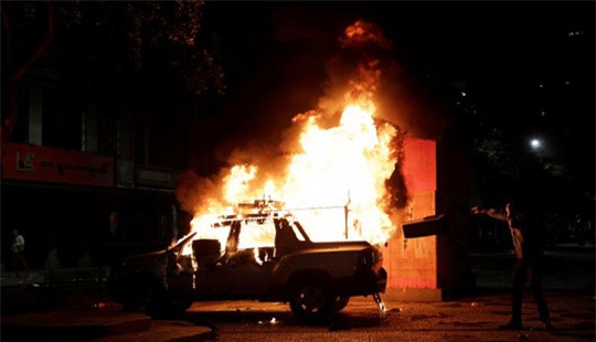 
Hình ảnh một chiếc xe hơi bị thiêu cháy trong cuộc biểu tình. Ảnh: Reuters
