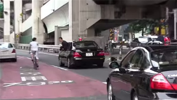 Nhân viên đoàn hộ tống Thủ tướng Nhật Bản cúi đầu chào và cảm ơn người đi xe đạp vì đã nhường đường - Ảnh 2.