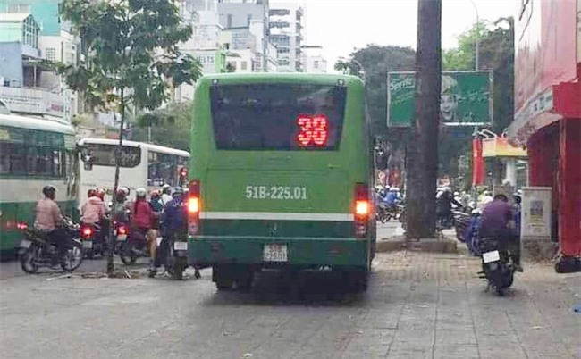 Clip: Không dừng chờ đèn đỏ, xe buýt bẻ lái leo thẳng lên vỉa hè Sài Gòn để lưu thông - Ảnh 2.