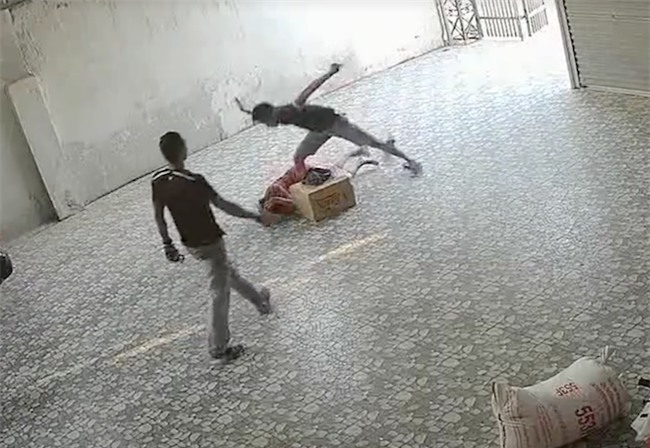 Video nhóm côn đồ xông vào đánh đập người phụ nữ nằm lê lết dưới nền nhà - Ảnh 4.