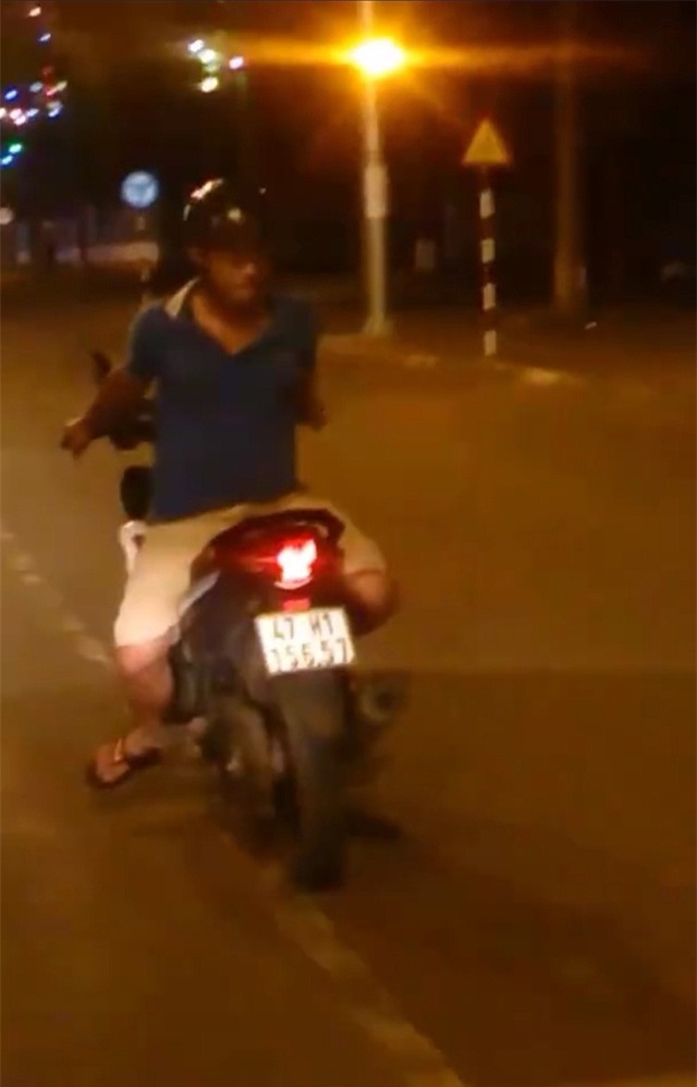  Nam thanh niên ngồi quay lung điều khiển xe máy (ảnh cắt từ clip) 