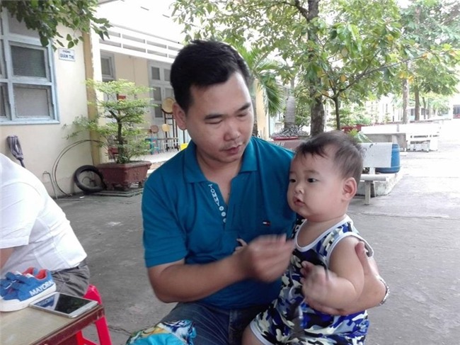 Chồng bế con 9 tháng tuổi theo vợ đi thi - ảnh 1