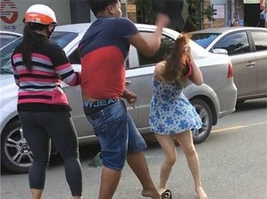 Người đàn ông dùng mũ bảo hiểm đánh vào đầu người phụ nữ (cắt từ clip).