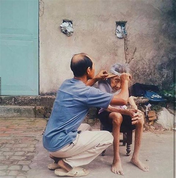 Bức ảnh người con trai cắt tóc cho mẹ già lay động trái tim cộng đồng mạng - Ảnh 1.