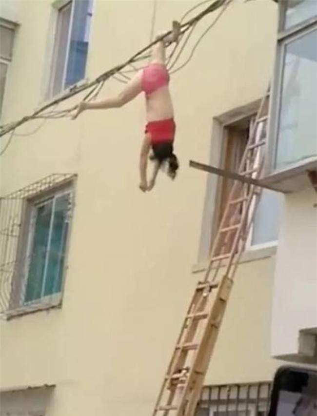 Mặc nội y lau cửa sổ, thế nào lại bị rơi xuống rồi mắc chân vào dây điện, người phụ nữ ngất giữa không trung - Ảnh 2.
