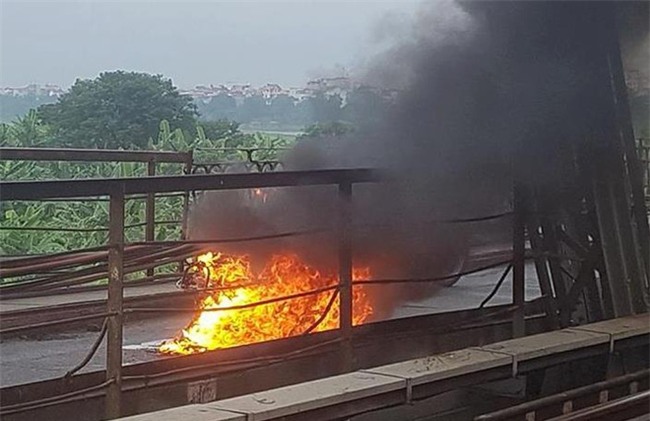 Người phụ nữ hoảng loạn nhảy khỏi xe máy đang bốc cháy trên cầu Long Biên - Ảnh 1.