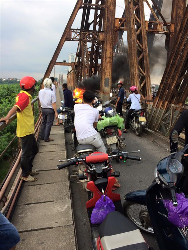Người phụ nữ hoảng loạn nhảy khỏi xe máy đang bốc cháy trên cầu Long Biên - Ảnh 2.