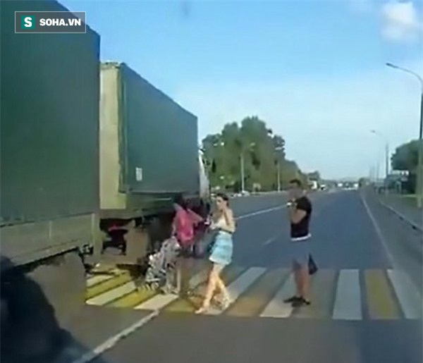 Mẹ bất cẩn, xe nôi chở em bé suýt bị xe tải nuốt chửng khi sang đường - Ảnh 2.
