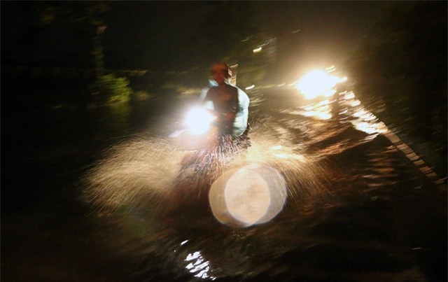 Nhiều người đi xe máy liều mình lao qua những đoạn ngập trên đường gom Đại lộ Thăng Long.