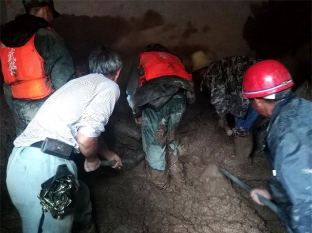 Hiện tượng sạt lở đất thường xuyên xảy ra sau mỗi đợt mưa lớn ở Trung Quốc, đặc biệt là ở các khu vực rừng núi. Lực lượng cứu hộ phải dùng cuốc xẻng để tìm kiếm những người bị mắc kẹt dưới đồng bùn đất. (Ảnh: AFP)