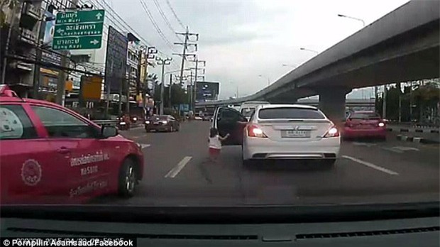 Bé gái đột ngột ngã lăn từ trên ô tô đang chuyển bánh xuống đường phố đông đúc - Ảnh 2.