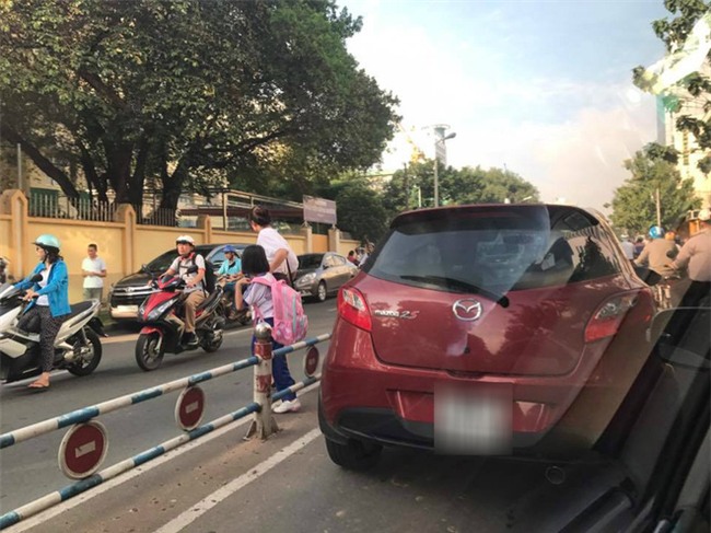 Dừng giữa đường, mẹ ngang nhiên mở cửa xe dẫn con vào trường học gây bức xúc - Ảnh 1.