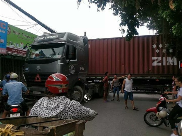 Bất chấp nguy hiểm, người dân thi nhau chui gầm container chắn ngang giữa đường để lưu thông - Ảnh 1.