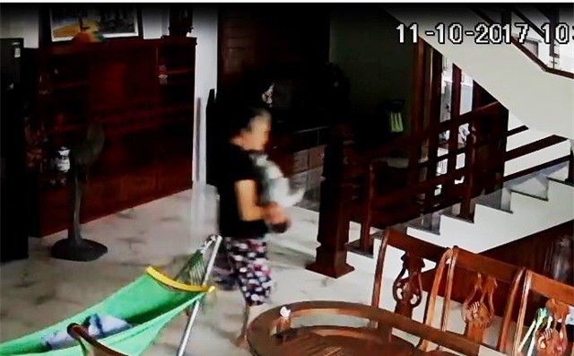 Bà L. có hành động giật, lắc cháu bé chưa đầy 5 tháng tuổi (ảnh cắt từ clip)