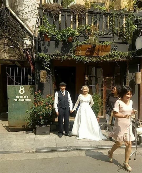 Hình ảnh cô dâu tóc bạc mặc váy cưới trắng, chú rể chống gậy móm mém cười khiến trên phố Hà Nội gây sốt mạng - Ảnh 1.