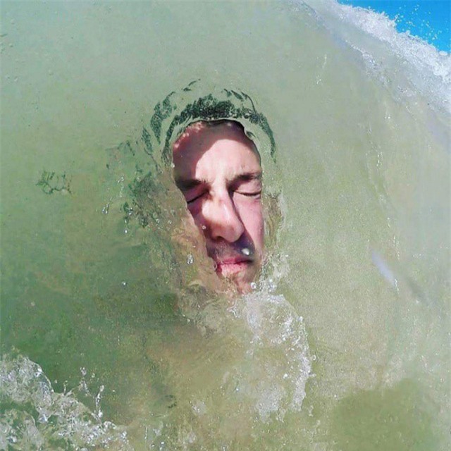 Khoảnh khắc sóng biển ôm trọn lấy khuôn mặt người đàn ông.