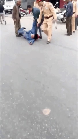 Xôn xao clip người đàn ông lăn lộn ra đường ăn vạ sau khi bị CSGT dừng xe vì vượt đèn đỏ - Ảnh 2.