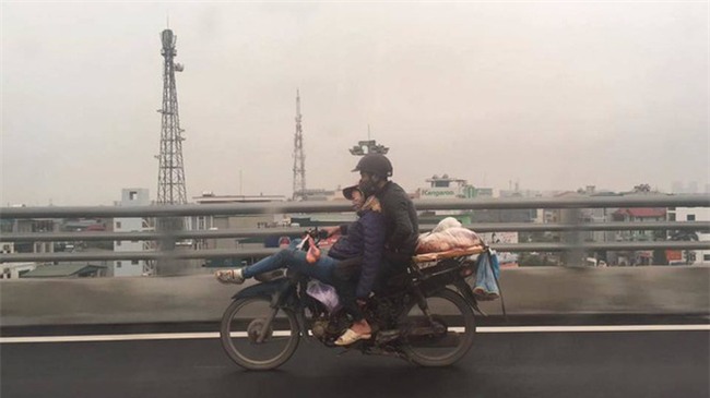 Tranh cãi về hình ảnh anh chồng ôm chặt cô vợ đang ngã lưng ngủ trước đầu xe máy - Ảnh 1.