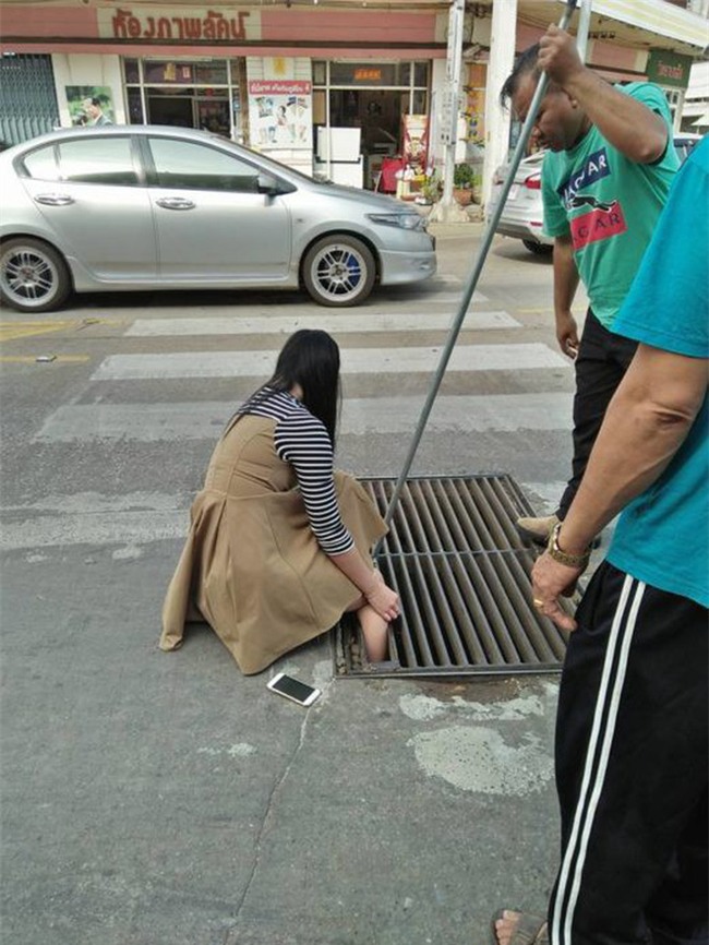 Thái Lan: Mải nghịch điện thoại, cô gái trẻ bất cẩn để lọt chân vào miệng cống ngầm, phải nhờ cứu hộ đến giải thoát - Ảnh 2.