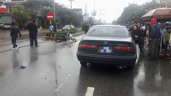 Ô tô biển xanh va chạm với xe máy, một phụ nữ bị hất văng hơn chục mét - Ảnh 1.