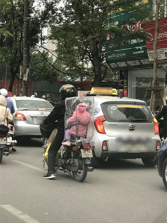 Giữa một sớm mai miền Bắc rét mướt, còn gì ấm áp hơn được ngồi trong cái bao nilon do bố sáng tạo nên - Ảnh 1.