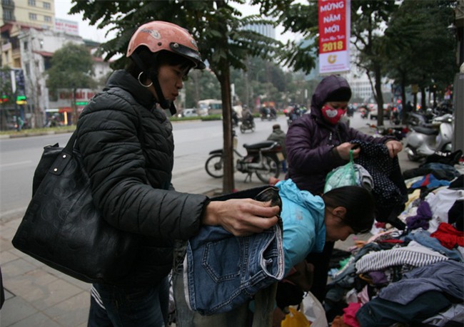 Nhiều người nghèo vui mừng khi kiếm được bộ quần áo miễn phí để diện Tết trên phố Hà Nội - Ảnh 1.