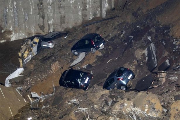 Chỉ sau một đêm, người dân bàng hoàng nhìn hố sâu 9m khổng lồ nuốt gọn nhiều ô tô, nhà cửa - Ảnh 9.