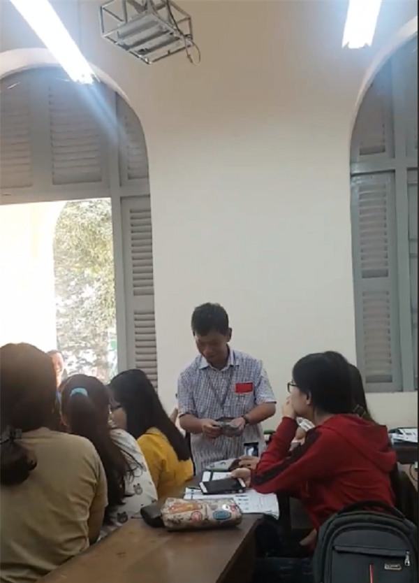 Thầy hiệu trưởng đến từng bàn lì xì cho các sinh viên.