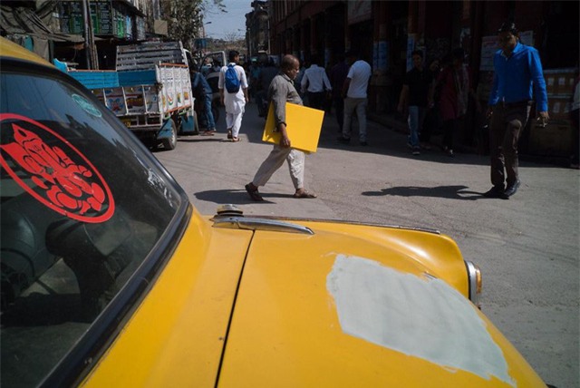 Chiếc xe bị mất một mảng sơn và người phụ nữ đang cầm trên tay một tấm gỗ cùng màu, trông cứ như vừa giật ra vậy.