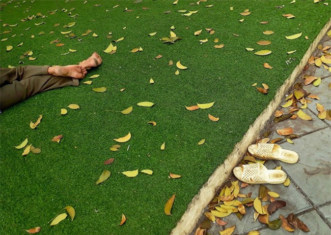Người bán hàng rong tranh thủ ngủ trưa ở một công viên dành cho trẻ em vẫn không quên bỏ dép ngoài bãi cỏ khiến dân mạng xúc động - Ảnh 2.