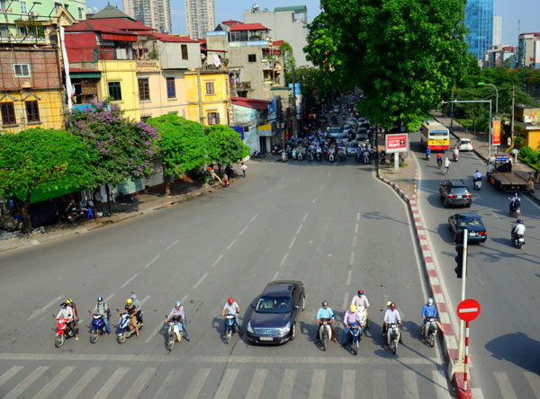 Tại các nút giao có đèn tín hiệu giao thông, người dân đứng tụt xuống những nơi có bóng cây, cách xa vạch kẻ đường, khác hẳn ngày thường.