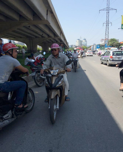 Để không tốn thời gian sang đường giữa ngày hè bỏng rát, nhiều người chọn cách đi ngược đường mặc dù biết vi phạm luật giao thông.