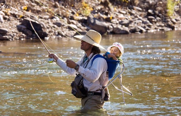 Cậu bé cười tươi rói khi được cha đưa đi câu cá trên sông Dolores, Colorado, Mỹ.