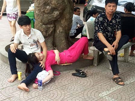 Bà bầu và người nhà vạ vật chờ khám bệnh giữa trưa nắng