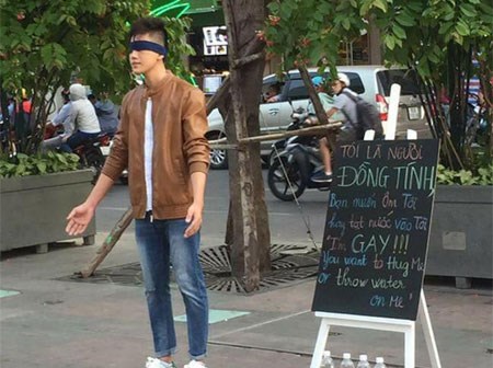 Chàng trai bịt mắt gây chú ý giữa phố đi bộ với tấm bảng