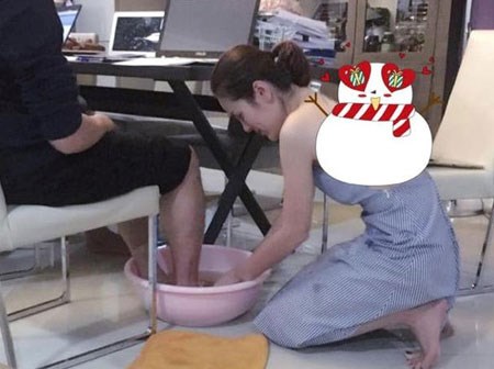 Bức ảnh nữ doanh nhân xinh đẹp rửa chân cho chồng