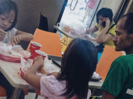 Hình ảnh người cha khắc khổ lặng lẽ nhìn 2 con gái nhỏ say sưa ăn gà rán khiến nhiều người rơi nước mắt