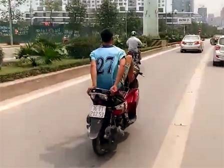 Thanh niên đi xe máy bằng chân trên làn buýt nhanh đối diện mức phạt nặng