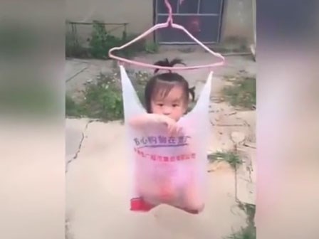 Cho con ngồi trong túi nilon rồi treo lên mắc áo để... hong cho mau khô, bà mẹ của năm đây rồi!