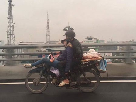 Tranh cãi về hình ảnh anh chồng ôm chặt cô vợ đang ngã lưng ngủ trước đầu xe máy