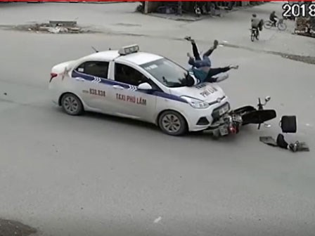 Phóng nhanh qua ngã tư, 2 người đi xe máy bị taxi hất lên nắp capo