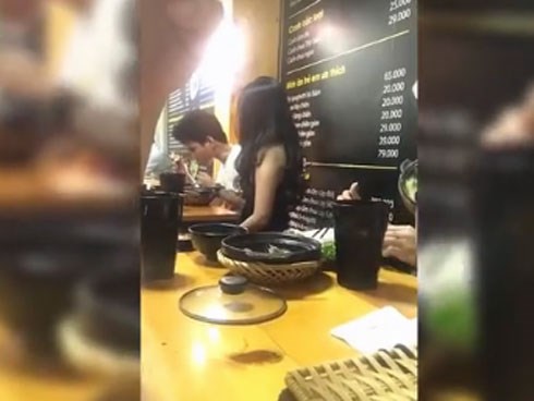Cô gái cần mẫn ngồi quạt cho bạn trai ăn