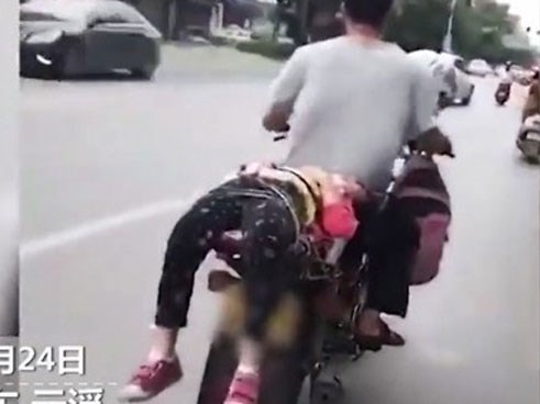 Hình ảnh ông bố trói con gái vào xe đưa đi học mặc con thét không muốn gây phẫn nộ cư dân mạng