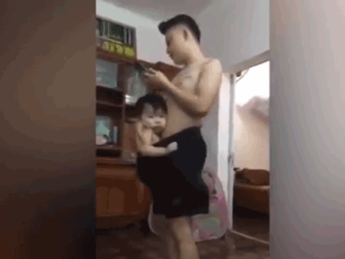 Ông bố của năm dùng quần đùi vừa địu con vừa hát ru