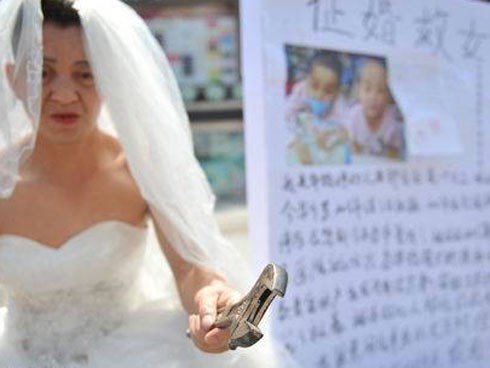 Người đàn ông nghèo mặc váy cưới đứng đường để quyên tiền chữa bệnh cho con khiến nhiều người xúc động nghẹn ngào