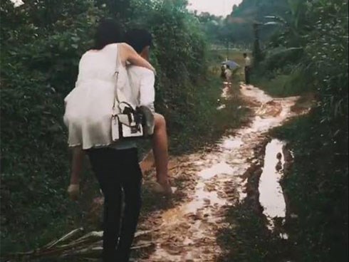 Cõng người yêu mặc váy trắng tinh, đi giày cao gót qua bùn lầy, thanh niên chẳng được khen mà khiến dân mạng tranh cãi