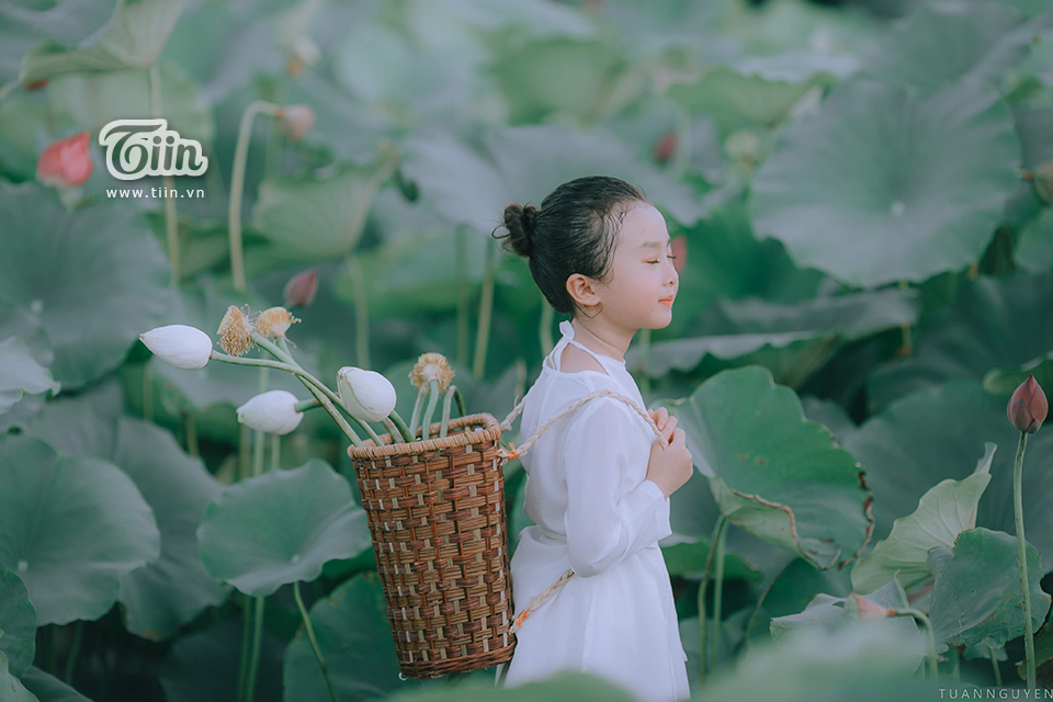 Tỏa sáng và đáng yêu, bé gái trong bức ảnh này chơi đùa cùng hoa sen trông rực rỡ. Điều này khiến bạn cảm thấy niềm vui và cảm xúc tràn đầy trong trái tim.
