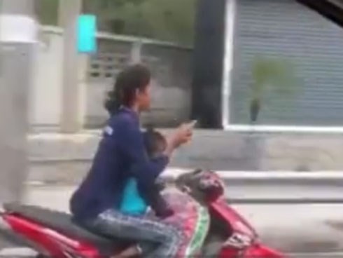 Nữ quái xế chở trẻ nhỏ vẫn vô tư buông hai tay lướt điện thoại