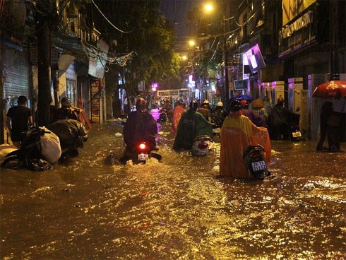 Người Hà Nội đội mưa sầm sập, rùng mình lội nước ngập rác về nhà