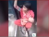 Xem mẹ trẻ bế con ngồi 'vắt vẻo' giữa hai toa tàu